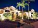 Nighttime front exterior view of a house with lush landscaping, palm trees, and a stone walkway at 204 Quail Trail Ct, Lake Mary, FL 32746