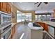 Open kitchen with wooden cabinets, island cooktop, stainless appliances, and breakfast nook at 204 Quail Trail Ct, Lake Mary, FL 32746