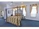 Bright main bedroom with a four-poster bed, accent lighting, and ensuite bathroom at 204 Quail Trail Ct, Lake Mary, FL 32746