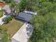 Aerial view of home featuring a new roof, screened porch, and concrete driveway amid lush landscaping at 235 Ruth Blvd, Longwood, FL 32750