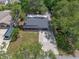 Aerial view of home featuring a new roof, screened porch, and concrete driveway amid lush landscaping at 235 Ruth Blvd, Longwood, FL 32750