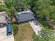 Aerial view of home featuring a new roof, screened porch, and concrete driveway amid lush landscaping at 235 Ruth Blvd, Longwood, FL 32750