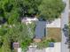 Birds-eye view of a home featuring a dark grey roof, a long driveway, and some tree coverage at 235 Ruth Blvd, Longwood, FL 32750
