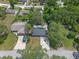 Aerial view of home featuring a new roof, screened porch, and concrete driveway amid lush landscaping at 235 Ruth Blvd, Longwood, FL 32750