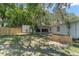 Backyard featuring lush green grass and mature trees. The home's exterior is white and well-maintained at 235 Ruth Blvd, Longwood, FL 32750