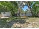 Backyard featuring lush green grass and mature trees. The home's exterior is white and well-maintained at 235 Ruth Blvd, Longwood, FL 32750