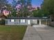 Charming single-story home with a covered front porch and driveway, surrounded by lush landscaping at 235 Ruth Blvd, Longwood, FL 32750