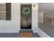 Close-up of a stylish black front door with a decorative wreath and 'HELLO' door mat at 235 Ruth Blvd, Longwood, FL 32750