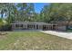 Charming single-story home with a screened porch and a convenient carport in a lush, green yard at 235 Ruth Blvd, Longwood, FL 32750