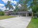 View of a well-kept house with a spacious driveway leading to a carport at 235 Ruth Blvd, Longwood, FL 32750