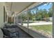 View of the cozy screened-in porch with outdoor seating and neighborhood views at 235 Ruth Blvd, Longwood, FL 32750