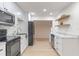 Bright kitchen with white cabinets, stainless steel appliances, and a seamless flow to the living area at 235 Ruth Blvd, Longwood, FL 32750