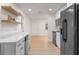 Well-lit kitchen with modern appliances, marble countertops, floating shelves, and wood-look floors at 235 Ruth Blvd, Longwood, FL 32750