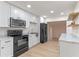 Open-concept kitchen featuring stainless steel appliances, marble countertops, and white cabinetry at 235 Ruth Blvd, Longwood, FL 32750