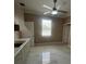 Bright kitchenette features marble floors, white cabinets, and stainless steel sink, illuminated by a ceiling fan with light at 2420 Graham Dr, Orlando, FL 32807