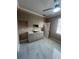 This kitchenette has white marble floors, white cabinets, and a stainless steel sink under a ceiling fan with lights at 2420 Graham Dr, Orlando, FL 32807