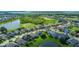 Overhead view of a suburban neighborhood featuring landscaped yards, a pond, and a glimpse of a nearby golf course at 2530 The Oaks Blvd, Kissimmee, FL 34746