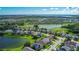 Wide aerial shot of a planned community, showcasing homes nestled around a lake and a neatly manicured golf course at 2530 The Oaks Blvd, Kissimmee, FL 34746