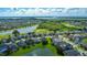 Scenic aerial of a neighborhood with well-maintained homes bordering a lake and golf course, illustrating a serene community setting at 2530 The Oaks Blvd, Kissimmee, FL 34746