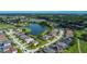 Expansive aerial view of a community with a golf course and a serene lake at 2530 The Oaks Blvd, Kissimmee, FL 34746