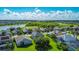 Scenic aerial view of a residential community with lush green lawns, a pond, and some homes with screened-in pools at 2530 The Oaks Blvd, Kissimmee, FL 34746