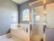 Bathroom with a tiled tub, shower, and light fixtures at 2530 The Oaks Blvd, Kissimmee, FL 34746