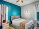 Cozy bedroom with a grey headboard bed, teal accent wall, bedside tables, and soft natural light at 2530 The Oaks Blvd, Kissimmee, FL 34746