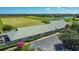 Aerial view of the community clubhouse with manicured landscaping, a golf course, and a glimpse of a nearby lake at 2530 The Oaks Blvd, Kissimmee, FL 34746