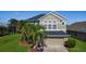 Two-story home with well-manicured lawn, front yard landscaping, and a two-car garage at 2530 The Oaks Blvd, Kissimmee, FL 34746