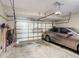 Clean, organized garage with epoxy floor, car, and a door at 2530 The Oaks Blvd, Kissimmee, FL 34746