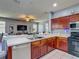 Open kitchen with wood cabinets, stainless steel appliances, and a view into the living area at 2530 The Oaks Blvd, Kissimmee, FL 34746