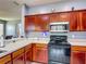 Well-lit kitchen featuring wood cabinetry, modern appliances, and ample counter space for all your cooking needs at 2530 The Oaks Blvd, Kissimmee, FL 34746