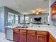 Open kitchen with wood cabinets, stainless steel appliances, and a view into the living area at 2530 The Oaks Blvd, Kissimmee, FL 34746