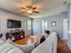 Spacious living room featuring a ceiling fan, a large television, and stylish décor at 2530 The Oaks Blvd, Kissimmee, FL 34746