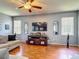 Cozy living room with hardwood floors, ceiling fan, and large windows bringing in natural light at 2530 The Oaks Blvd, Kissimmee, FL 34746