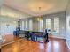 Living room featuring wood floors, a large mirror, and multiple windows for ample natural light at 2530 The Oaks Blvd, Kissimmee, FL 34746