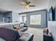 Open loft area with comfortable seating, a ceiling fan, and a view of the office space at 2530 The Oaks Blvd, Kissimmee, FL 34746