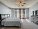 This carpeted main bedroom boasts abundant light from its three windows and ceiling fan at 2530 The Oaks Blvd, Kissimmee, FL 34746