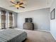 Spacious main bedroom with a large bed, dresser with TV, and ample natural light from windows at 2530 The Oaks Blvd, Kissimmee, FL 34746