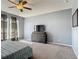 Spacious main bedroom featuring a ceiling fan, gray walls and a dresser with a TV at 2530 The Oaks Blvd, Kissimmee, FL 34746