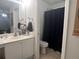 This bathroom has a white vanity, a mirror, and a toilet and shower behind a partial wall at 2770 Club Cortile Cir # A, Kissimmee, FL 34746