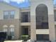A multi-level exterior view of a condominium building with beige stucco and dark trim at 2770 Club Cortile Cir # A, Kissimmee, FL 34746