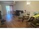 This living room has wood floors, a ceiling fan, and a dining table set next to a dark couch at 2770 Club Cortile Cir # A, Kissimmee, FL 34746