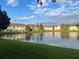 Residential buildings overlooking a large pond with lush green lawns at 2770 Club Cortile Cir # A, Kissimmee, FL 34746