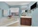 Well-lit bathroom features a garden tub, dark cabinetry, and white countertops for a clean aesthetic at 3196 Verbena Ct, Deltona, FL 32725
