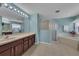 A blue bathroom with a white shower, a garden tub, a large mirror, and a double sink at 3196 Verbena Ct, Deltona, FL 32725