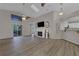 Open living room with wood floors, high ceilings, fan, fireplace, and sliding glass door to the outside at 3196 Verbena Ct, Deltona, FL 32725