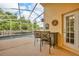 Screened-in patio with seating area overlooking a sparkling pool and lush greenery, perfect for outdoor relaxation at 3196 Verbena Ct, Deltona, FL 32725