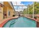 Inviting screened-in pool with a spa, complemented by a patio and backyard scenery at 3196 Verbena Ct, Deltona, FL 32725