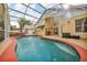 Screened-in pool area with patio, hot tub, and lush greenery, perfect for outdoor relaxation and entertainment at 3196 Verbena Ct, Deltona, FL 32725